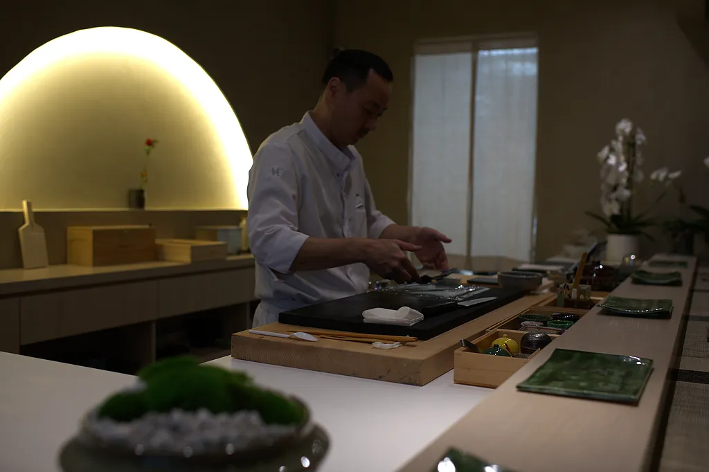Chef Atsutaka Chikaraishi in profile behind the counter