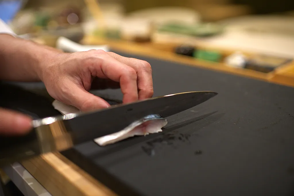 A yanagiba blade resting on the cutting board