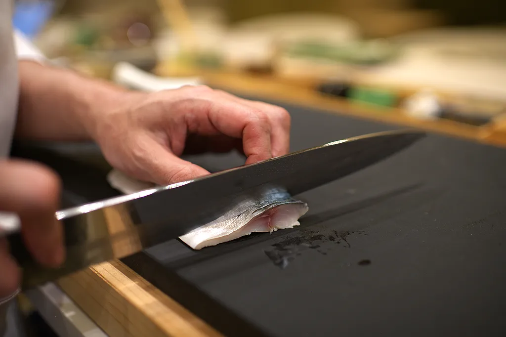 The edge of a yanagiba against the board