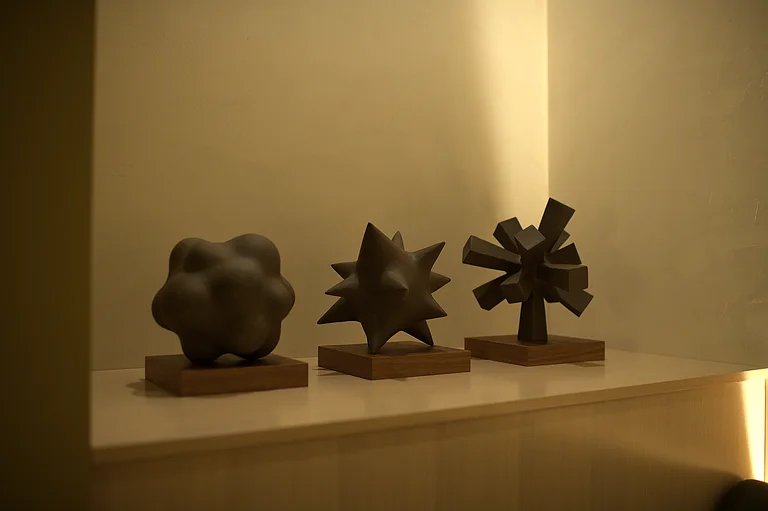 Three small bronze sculptures on a ledge