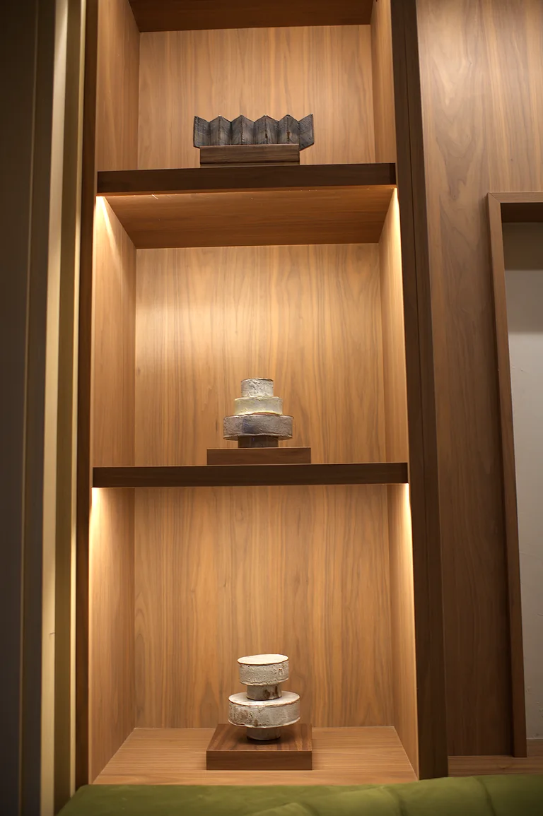 Ceramic vessels on lit oak shelves