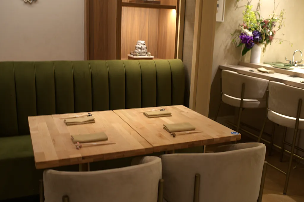 A table set against the banquette, flowers at its centre